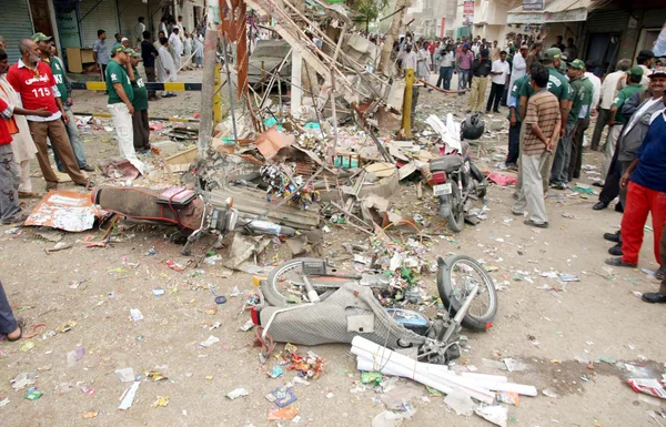 Se reúnen en el sitio después de la explosión de la bomba en el área de Landhi en Karachi — Foto de Stock