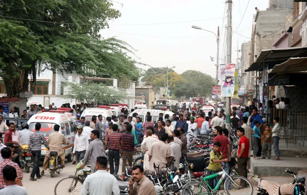 Riunirsi nel sito dopo l'esplosione della bomba nella zona di Landhi a Karachi — Foto Stock