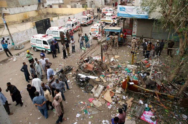 Se reúnen en el sitio después de la explosión de la bomba en el área de Landhi en Karachi —  Fotos de Stock