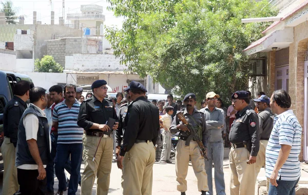 Ufficiali di polizia e si riuniscono sul posto dopo l'esplosione della bomba nella zona di Landhi a Karachi — Foto Stock