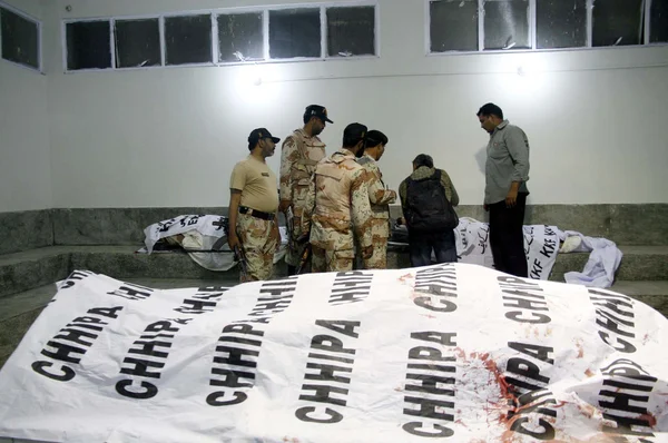 Funcionários de Rangers olham corpo morto de guarda florestal após explosão de bomba perto de um posto de controle de Rangers Sede na área de Korangi em Karachi — Fotografia de Stock