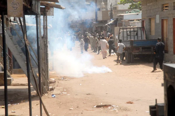 Police officials fire tear-gas shells to disperse protesters during protest demonstration of residents of Lyari against increasing incidents of targeted killings in the area — Stock Photo, Image