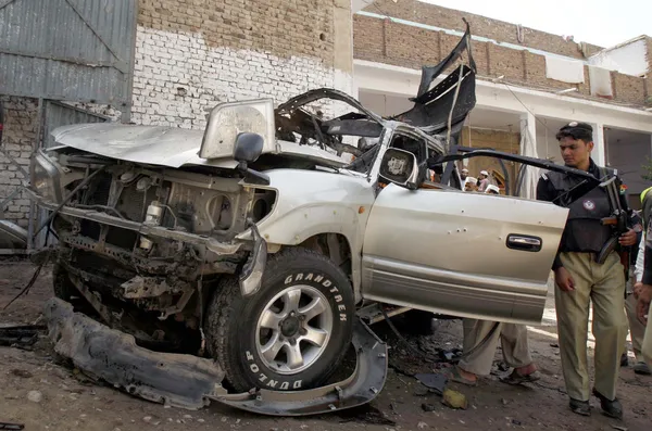 Funzionari di polizia ispezionano sul posto dopo una furiosa esplosione suicida su Pajaggi Road nel sobborgo di Peshawar — Foto Stock