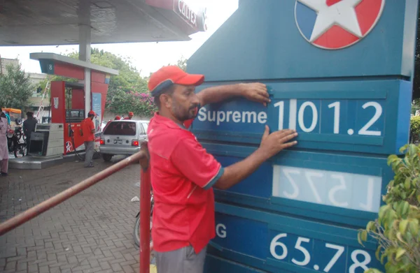 Fuel station employee displays new prices of petroleum products at a fuel station in Karachi — Stock Photo, Image