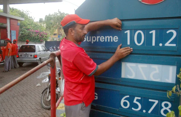 Fuel station employee displays new prices of petroleum products at a fuel station in Karachi — Stock Photo, Image