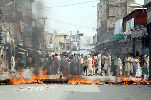 Residents of Nadeem Shaheed road block road burn tyres and bushes as they are protesting against electricity load shedding in their area — Stock Photo, Image