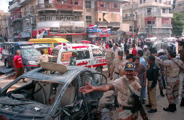 Autoridades de segurança inspecionam o local de uma explosão de bomba visando o comboio do Supremo Tribunal de Justiça de Sindh, Baqar Maqbool, na Burns Road, em Karachi — Fotografia de Stock