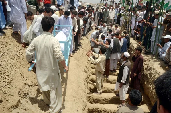 Choradores xiitas enterram cadáveres de vítimas de explosão de bomba suicida da área de Aliabad na cidade de Hazara após sua oração fúnebre no cemitério em Quetta — Fotografia de Stock