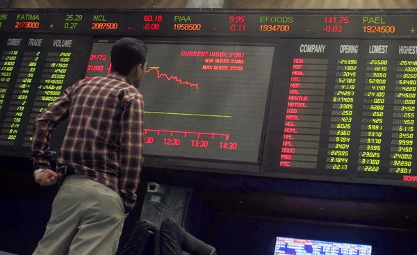 Um comerciante paquistanês monitora os preços do comércio na Bolsa de Valores de Karachi (KSE), em Karachi, na terça-feira, 02 de julho de 2013 Fotos De Bancos De Imagens