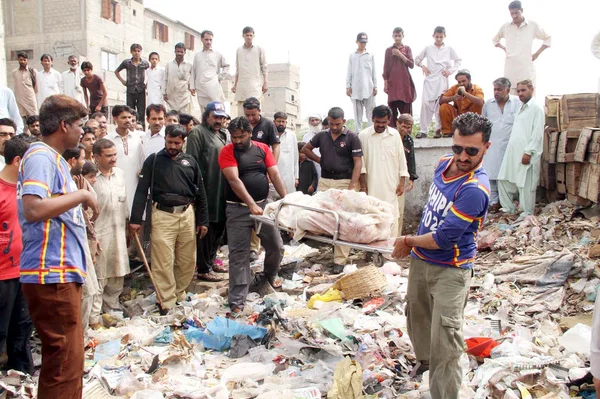 Rescue Volunteers shifting a tortured sack pack body to morgue that found near Old Sazbi Mandi from a garbage dump, in Karachi — Stock Photo, Image