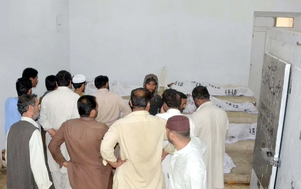 Le persone si riuniscono vicino a cadaveri di passeggeri, che hanno ucciso aggressori armati sconosciuti a Giyani Pul vicino all'area di Mach nel distretto di Bolan, presso l'ospedale locale di Quetta — Foto Stock