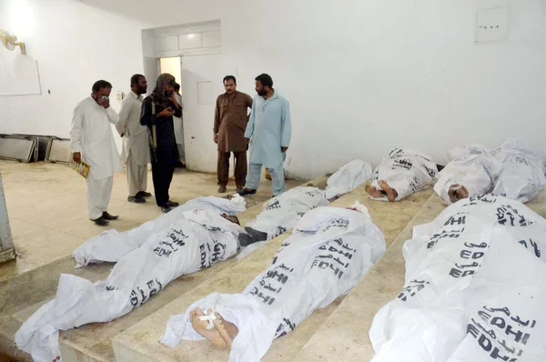 Люди собираются возле трупов пассажиров, убивших неизвестных вооруженных нападавших в Гияни-Пуле недалеко от района Мах в районе Болан, в местной больнице в Кветте — стоковое фото