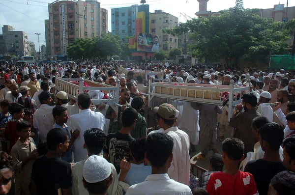 La gente lleva ataúd de las víctimas que murieron en la explosión de bombas durante el partido de fútbol en Bazinjo Road en Sango Lane, área de Lyari en Karachi —  Fotos de Stock