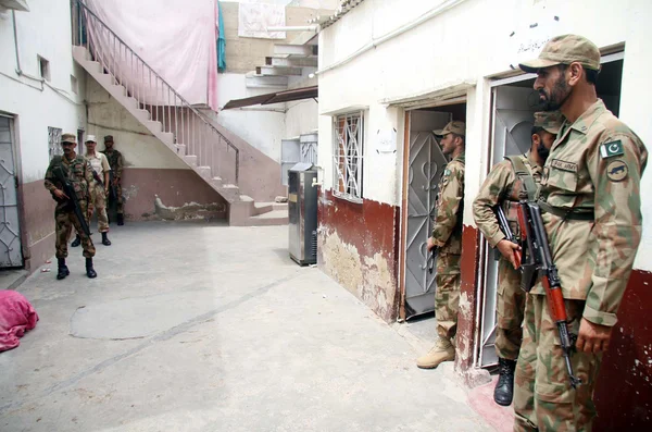 Security officials stand alert to avoid untoward incidents at a polling station during by-election for PS-95 at Orangi area in Karachi — Stock Photo, Image