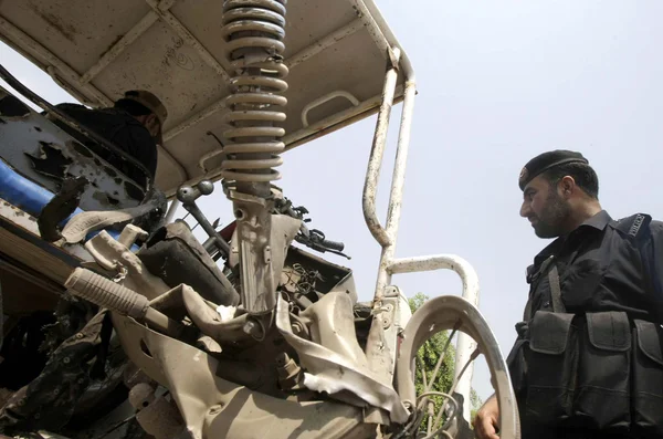 Funcionarios de seguridad se mantienen alerta en el sitio después de una explosión controlada a distancia en Kohat Road cuando el convoy de fuerzas de seguridad pasaba por la zona de Bazid Khel —  Fotos de Stock