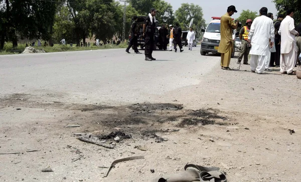 Säkerhet tjänstemän stå varning på platsen efter en radiostyrd blast på kohat road när konvojen av säkerhetsstyrkorna passerar genom området bazid khel — Stockfoto