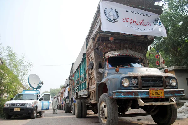 Trucks loaded with relief goods, donated by Khyber Pakhtunkhwa Chief Minister, stand ready for dispatch to earthquake hit areas of Balochistan — Stock Photo, Image