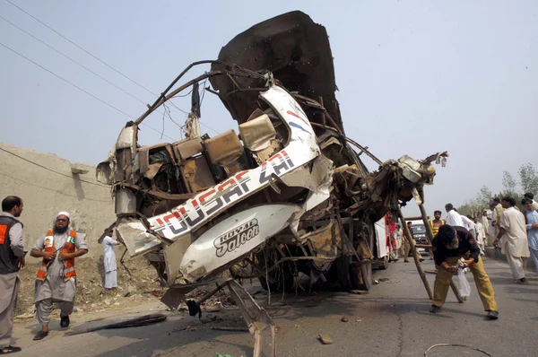 Recues funcionários ocupados em recues trabalhar no local após uma explosão dentro de um ônibus na Charsadda Road em Peshawar — Fotografia de Stock