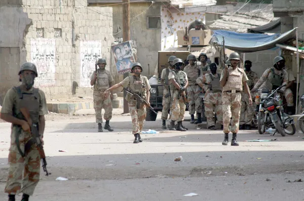 Funcionarios de guardaparques ocupados en operaciones de búsqueda contra criminales después del enfrentamiento entre dos grupos armados en el área de Lyari —  Fotos de Stock