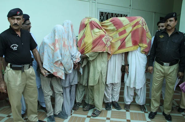 Oficial da polícia mostrando sequestradores de bicicletas presos para pessoas da mídia durante uma conferência de imprensa no escritório da ACLC em Karachi — Fotografia de Stock