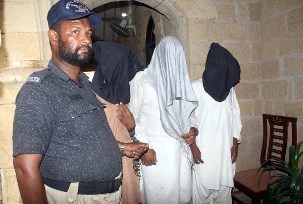 Police official showing recovered weapon from arrested criminals of Lyari gang war alleged in threaten attack and asking extortion to President Mamnoon Hussain relative — Stock Photo, Image