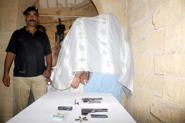 Επίσημη αστυνομία δείχνει συλληφθέντες εκβιαστές και ανακτημένα όπλα κατά τη διάρκεια επιδρομής στην περιοχή maripur, κατά τη διάρκεια συνέντευξης τύπου στις εγκαταστάσεις του siu στο Καράτσι — Φωτογραφία Αρχείου