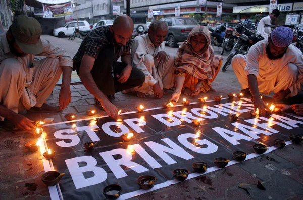 Μέλη της κοινωνίας των πολιτών φωτίσει πήλινα λάμπες, καθώς είναι διαμαρτύρονται εναντίον μας επίθεση κηφήνων και απαιτητική για την απελευθέρωση των πακιστανικών νευροεπιστήμονας, dr.aafia siddiqui — Φωτογραφία Αρχείου