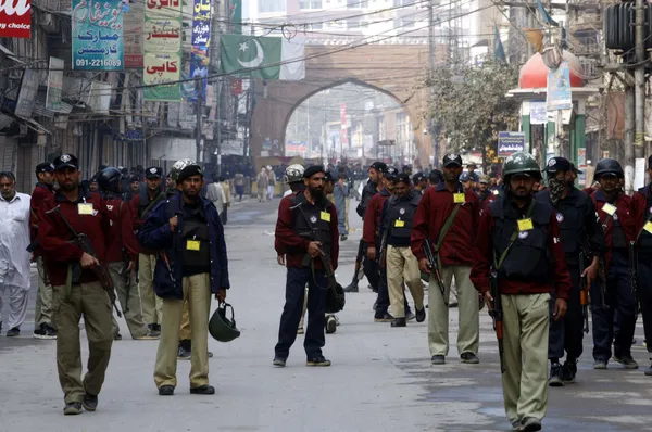Сотрудники полиции сопровождают для охраны религиозных шествий в связи с 8-м Мохаррам-уль-Харам, проходят через дорогу в Пешаваре — стоковое фото