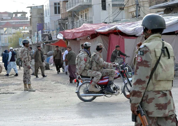 Funcionarios de seguridad acordonan el área de Liaquat Bazar después de atacar tiendas y puestos por malhechores que pasan por la carretera mientras celebran mitin contra los disturbios de Rawalpindi —  Fotos de Stock