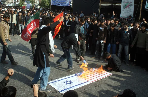 Aktivister av imamia elever organisationen (iso) bränning usa och israel flaggor efter middagsbönen under chehlum (40: e dag) av imam hussain (Asplund) procession — Stockfoto