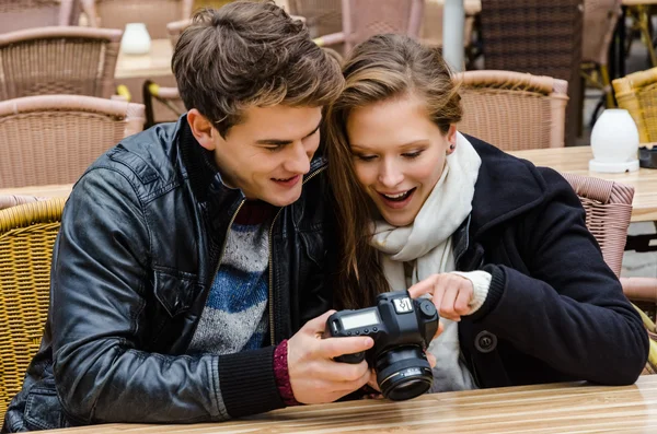 Coppia guardando le fotografie sulla fotocamera digitale al ristorante — Foto Stock