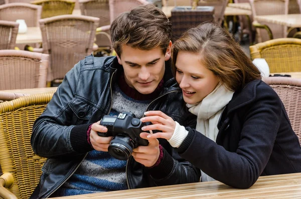 Pár na kameru v restauraci při pohledu na fotografie — Stock fotografie