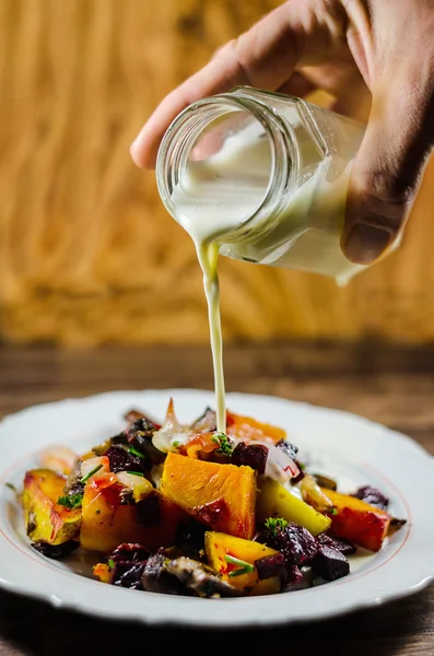 Mão derramando leite em salada saudável — Fotografia de Stock