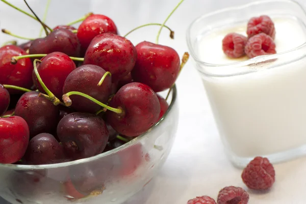 Skål med körsbär och yoghurt med hallon — Stockfoto