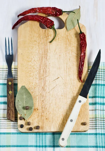 Tábua de cortar, pimenta, garfo e faca — Fotografia de Stock