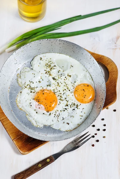 Gebakken eieren met kruid op de koekenpan — Stockfoto