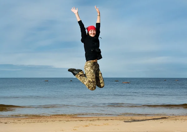 Glada kvinnor hoppa på stranden — Stockfoto