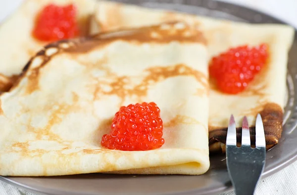Pancakes with red caviar and fork — Stock Photo, Image