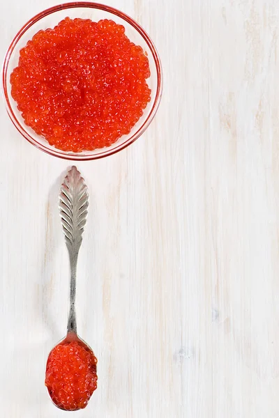 Red caviar in the glass jar and silver spoon — Stock Photo, Image