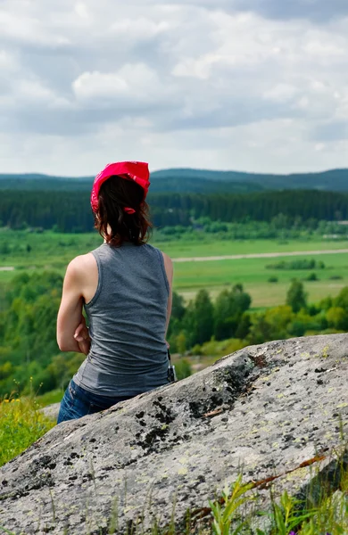 Vrouw ontspannen zittend op de rots — Stockfoto