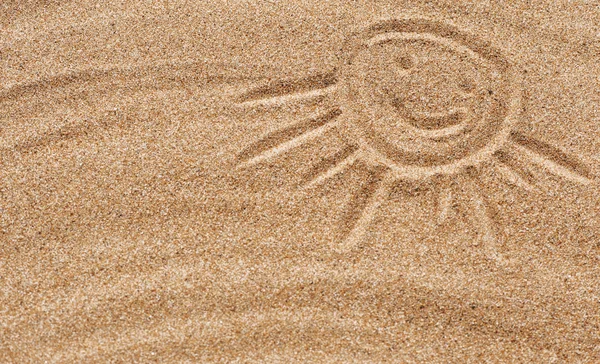Улыбающееся солнце на песке — стоковое фото