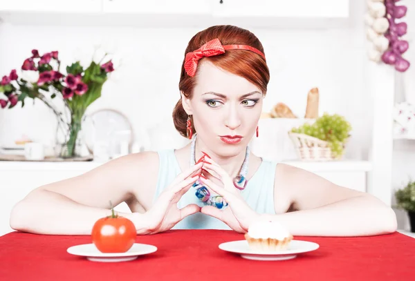 Mulher escolhendo entre comida saudável e bolo — Fotografia de Stock