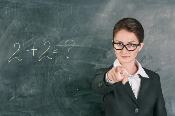 Woman teacher teaching maths and pointing on someone — Stock Photo, Image