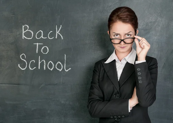 Teacher and phrase Back to school on the school blackboard — Stock Photo, Image