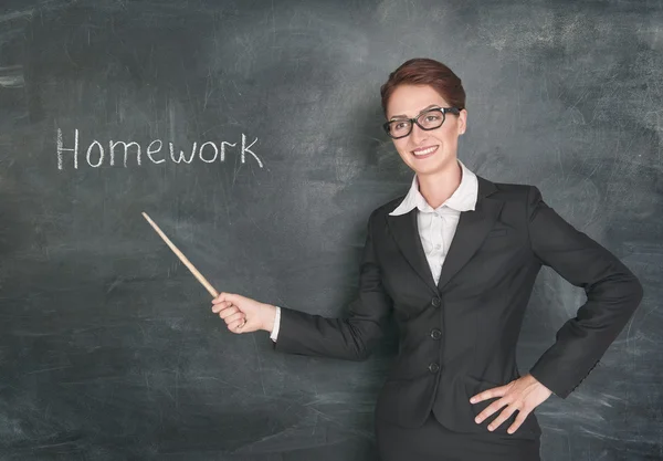 Lachende leraar met aanwijzer en zin huiswerk — Stockfoto