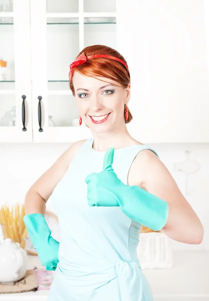 Gelukkige huisvrouw met rubberen handschoenen duimen opdagen — Stockfoto