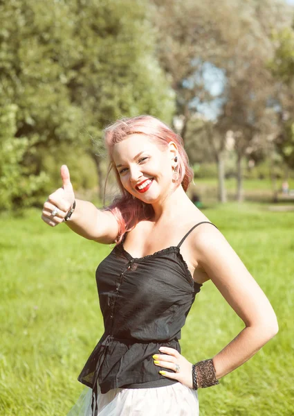 Beautiful woman showing thumbs up outdoor — Stock Photo, Image