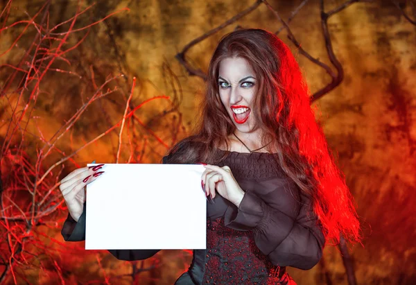 Хэллоуинская ведьма держит лист бумаги — стоковое фото