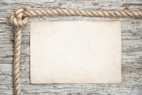 Rope, sheet of paper and wood background