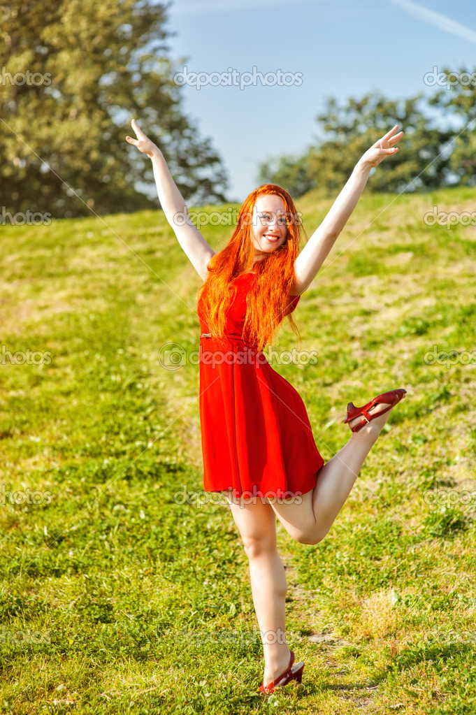 Redhead bending outdoor woman